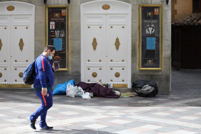 Archivo - Una persona sintecho duerme en la calle Arenal de la capital.