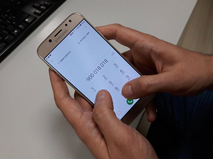 Archivo - Una persona llamando al teléfono del acoso escolar