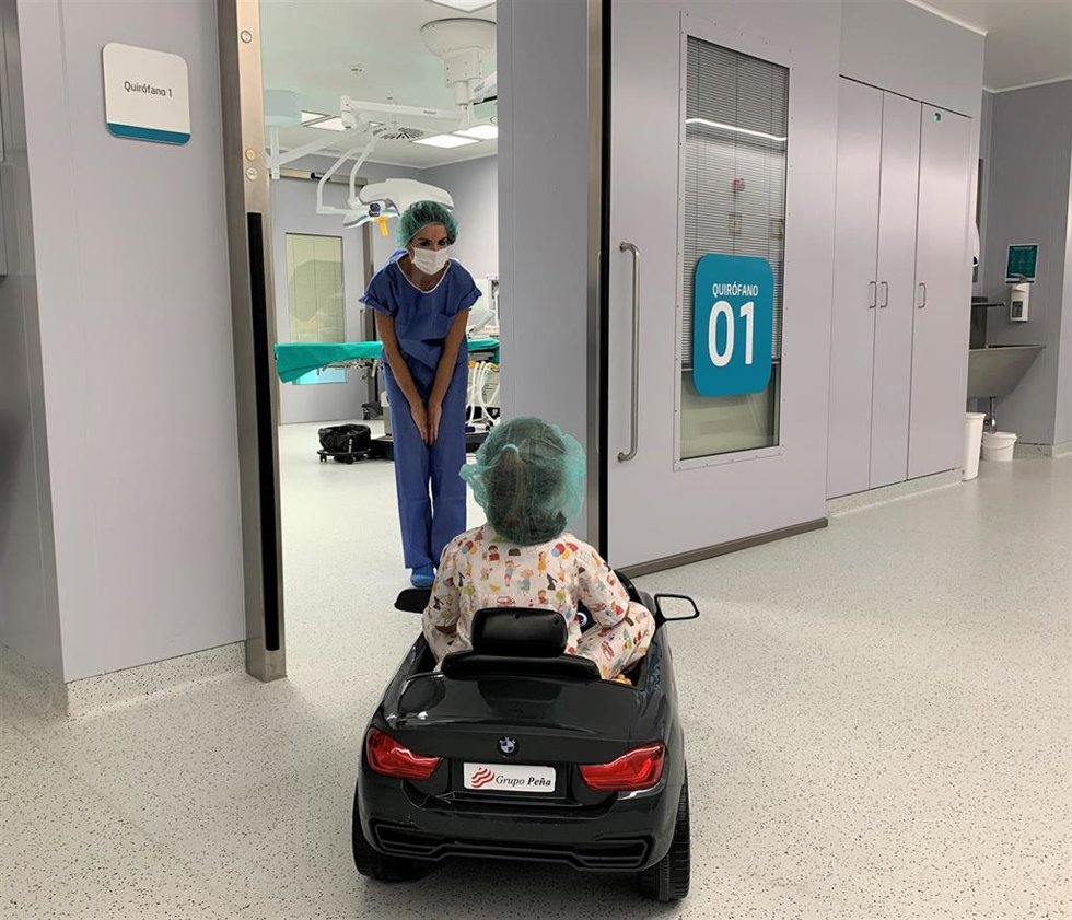 La doctora Jiménez con una paciente que conduce un cochecito hasta la entrada a quirófano.