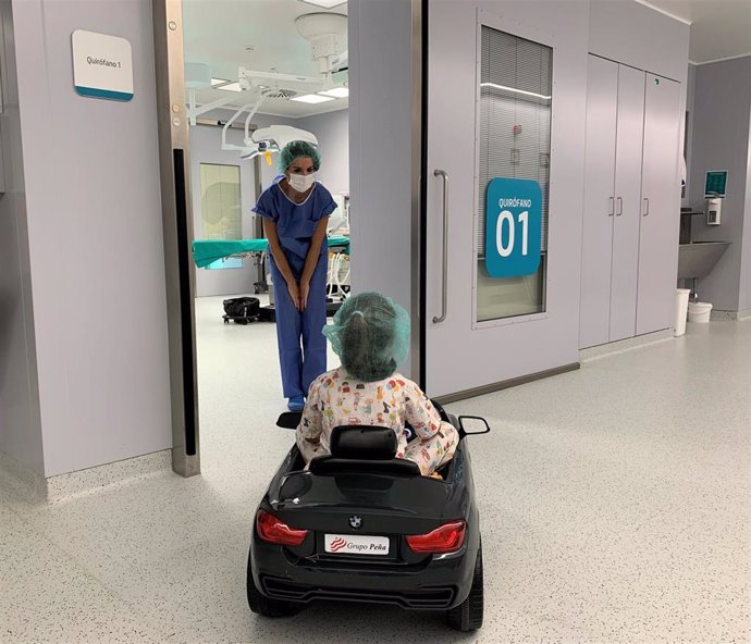 La doctora Jiménez con una paciente que conduce un cochecito hasta la entrada a quirófano.
