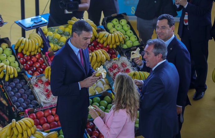 El presidente del Gobierno, Pedro Sánchez (1i), junto al presidente de la Junta, Juanma Moreno (1d);  la ministra de Transportes, Movilidad y Agenda Urbana, Raquel Sánchez y el alcalde de Sevilla, Juan Espadas (c), se paran en un stand de Mercasevilla, 