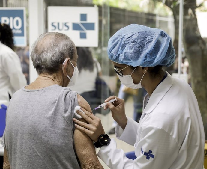 13 September 2021, Brazil, Rio de Janeiro: A health worker gives a coronavirus vaccine to an elderly woman third dose, as part of the third dose vaccination campaign for the elderly over 95 years old, at CMS Joao Barros Barreto hospital. Photo: Gabriel 