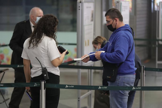 Un pasajero pasa su billete por el control para acceder a un tren en la estación de Atocha durante la tercera jornada de huelga de maquinistas de Renfe