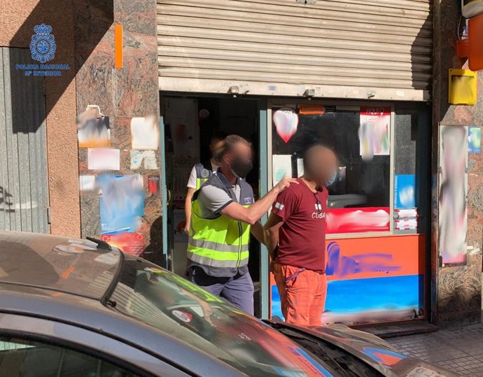 Un agente de la Policía Nacional, con uno de los detenidos por colaborar con una organización criminal de blanqueo.