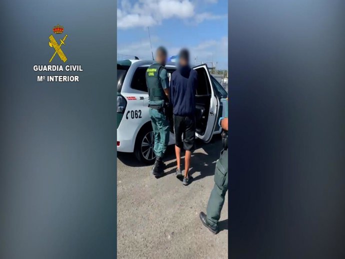 Agentes de la Guardia Civil introduciendo al detenido en un vehículo oficial