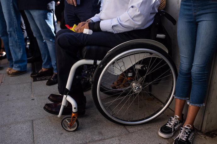 Un hombre en silla de ruedas sostiene una bandera de España, durante una ofrenda floral celebrada en recuerdo a las víctimas del etarra Henri Parot la Plaza de la República Dominicana, a 18 de septiembre de 2021, en Madrid, (España). Este es uno de los 