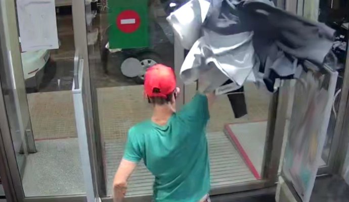 Archivo - Imagen captada por una cámara de seguridad, en la que se ve al sospechoso pasando la ropa robada por encima del arco de seguridad.