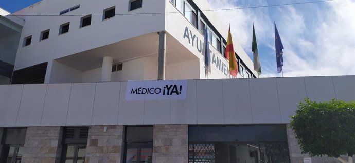 Ayuntamiento de La Algaba con un cartel de protesta por la eliminación de un equipo de urgencias sanitarias