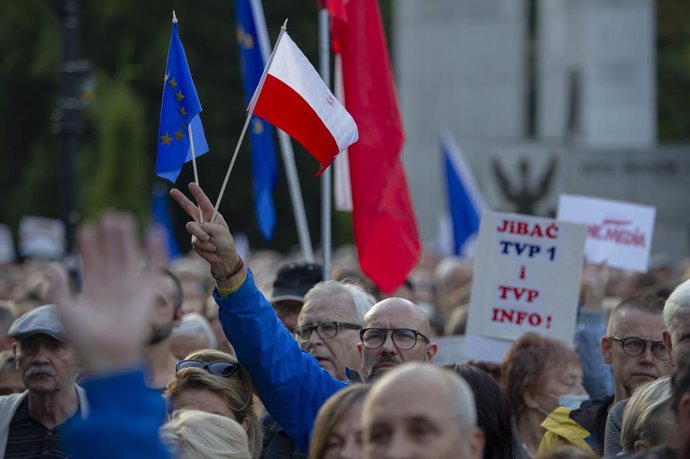 Archivo - 10 August 2021, Poland, Warsaw: A man gestures a victory sign while holding flags of Poland and the European Union during a protest in front of the Polish Parliament (Sejm) as part of a nationwide protest against a proposed bill by the lawmake