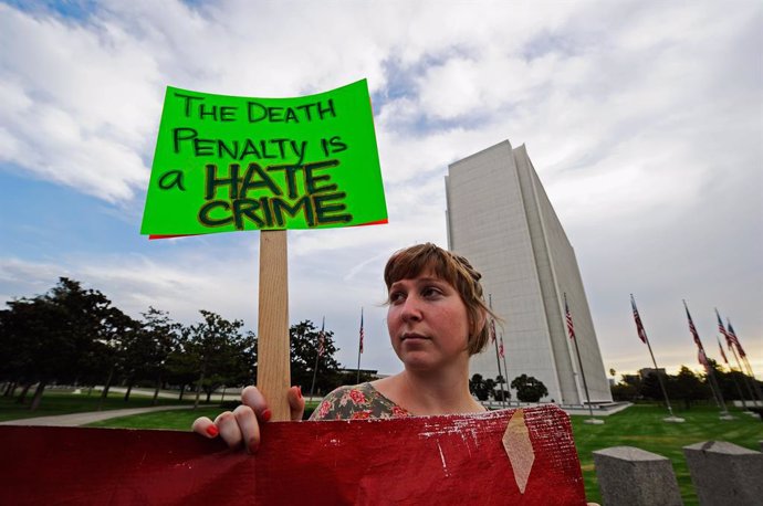 Archivo - Una manifestante contra la pena de muerte sostiene un cartel durante una protesta en Los Ángeles.