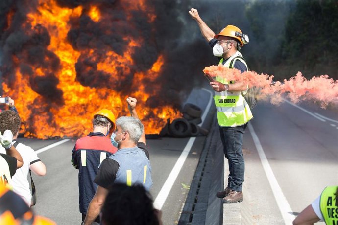 Archivo - Un trabajador de Alcoa porta una bengala durante la concentración para defender el futuro de la fábrica de aluminio en San Cibrao, a 19 de julio de 2021, en San Cibrao, Cervo Lugo, Galicia (España). Detrás de él, los trabajadores han cortado u