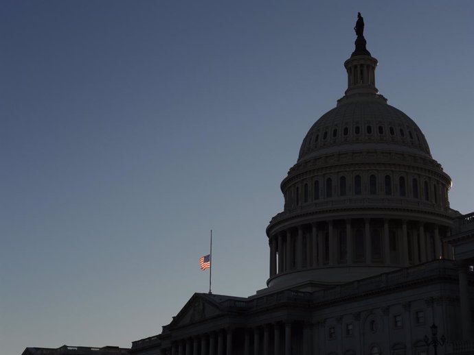 Archivo - 09 January 2021, US, Washington: A US flag flies at half-mast at the US Capitol in memory of police officer Brian Sicknick. Sidnick died as a result of injuries sustained during a riot by pro-Trump supporters who stormed and vandalized the Cap