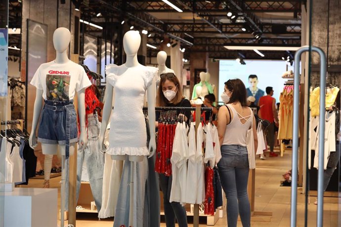 Archivo - Personas con mascarilla en el interior de una tienda de ropa en el primer día de la fase 1 en Madrid, en la que se permite reapertura de locales y establecimientos minoristas con una superficie igual o inferior a 400 metros cuadrados. En Madri