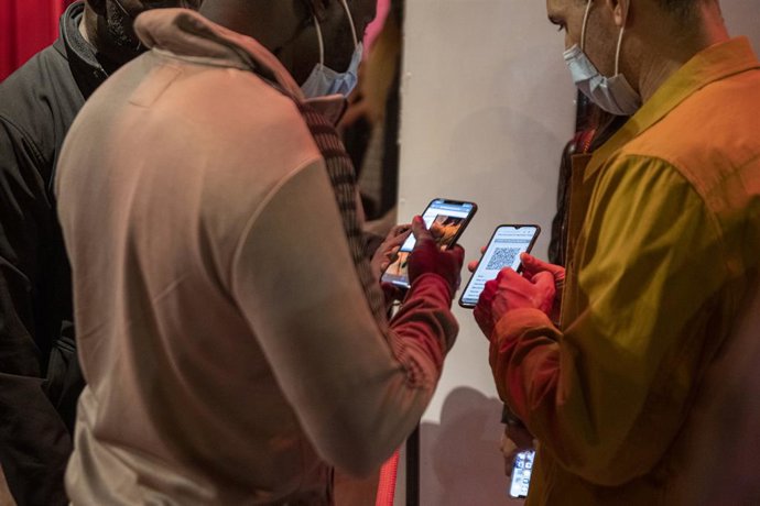 Una persona mostra un codi QR per entrar a un local d'oci nocturn el dijous