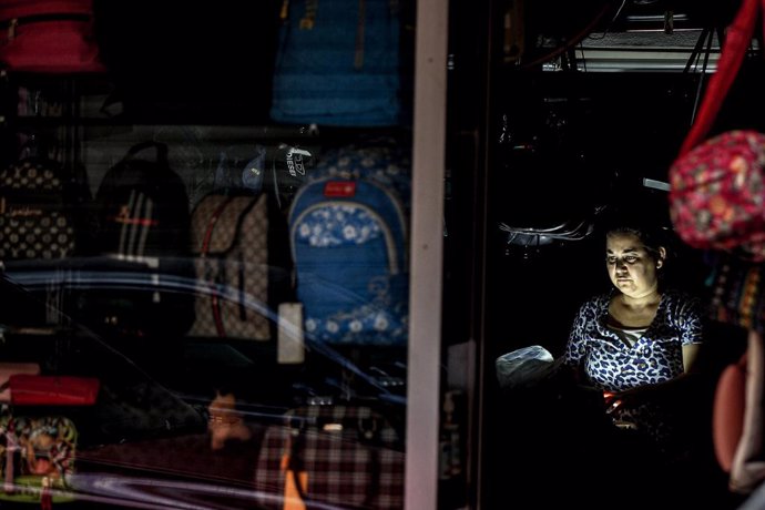 24 September 2021, Lebanon, Beirut: A Lebanese woman sits inside a suitcases shop during an electricity outage. Photo: Marwan Naamani/dpa