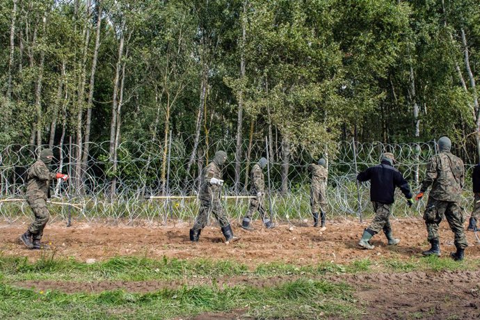 Archivo - 01 September 2021, Poland, Wojnowce: Polish soldiers build a razor-wire fence along the border with Belarus close to the village of Minkowce. The Polish government is introducing a State of Emergency on the border with Belarus in two voivodesh