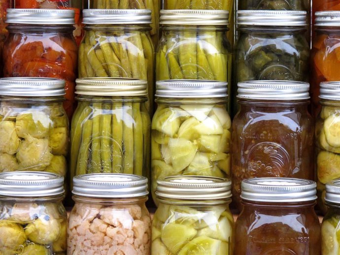 Pickled vegetables including carrots, green beans, tomatoes, and cauliflower are on display at a farmer market during the Derby Day Wine and Whiskey Walk event.