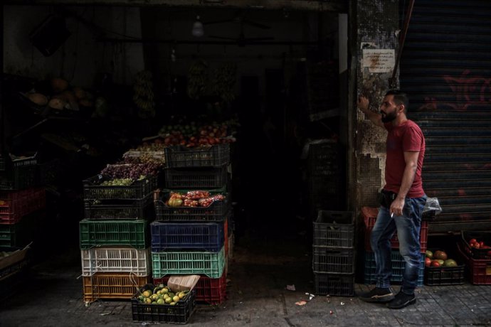 24 September 2021, Lebanon, Beirut: A vendor stands outside a grocery shop during an electricity outage. Photo: Marwan Naamani/dpa