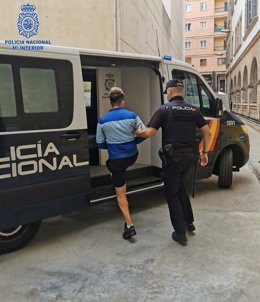 Un agente de la Policía Nacional junto al detenido.