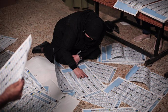 10 October 2021, Iraq, Baghdad: An Iraqi election committee staff member counts the votes for the Iraqi parliamentary elections, at a polling station in Baghdad's Karada district. Photo: Ameer Al Mohammedaw/dpa