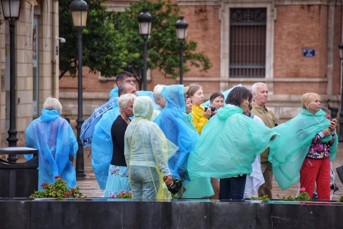 Archivo - Un grupo de turistas siguen una visita guiada por el centro de Valencia con chubasqueros para protegerse de la lluvia, durante el temporal de gota fría que afecta a la zona de Levante, en Valencia (España) a 11 de septiembre de 2019.