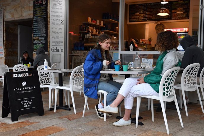Personas en una cafetería en Sídney (Australia) tras el fin de un confinamiento de más de cien días en la ciudad