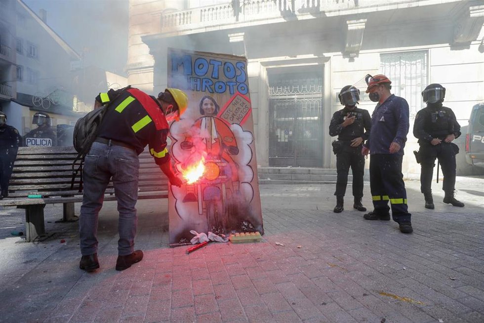 Un hombre prende fuego a una pancarta con un retrato de la ministra de Industria, Reyes Maroto, en una concentración conjunta de trabajadores de las fábricas de Alcoa y de Vestas situadas en A Mariña (Lugo), frente a la Subdelegación del Gobierno, a 10
