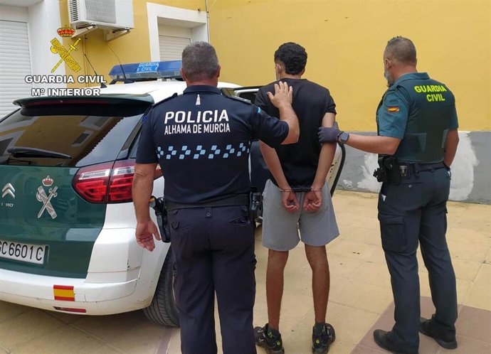 Uno de los detenidos junto a dos agentes de la Guardia Civil