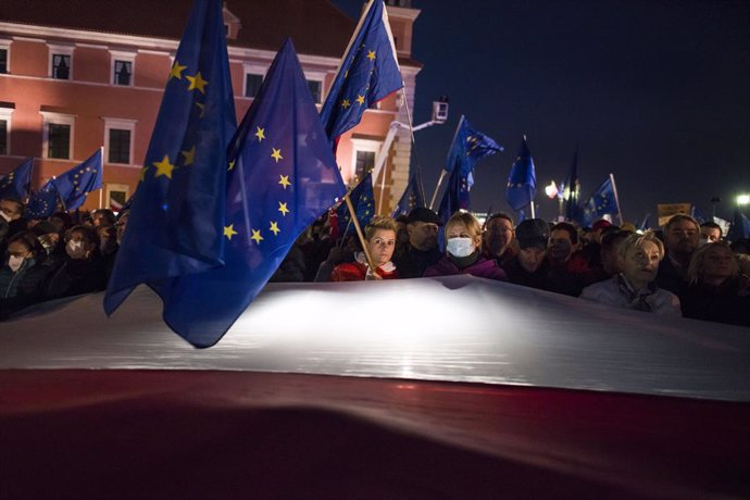10 October 2021, Poland, Warsaw: Protesters hold EU and Polish flags during the pro-EU rally to show support for the European Union after the constitutional court ruled earlier this week that the Polish constitution overrides EU laws. Photo: Attila Huse