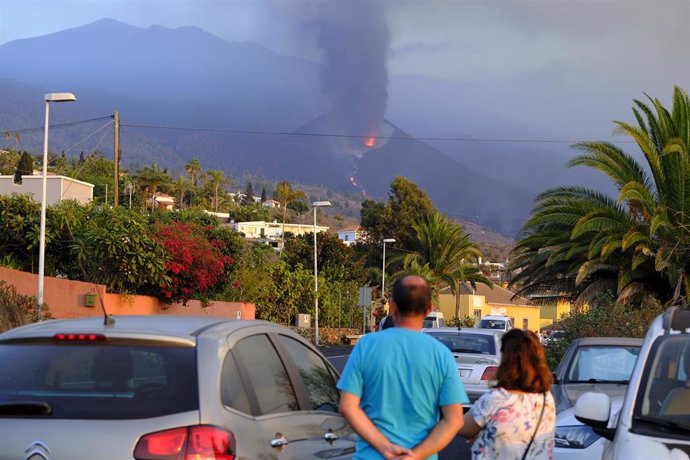 Dos personas contemplan la erupciómn del volcán de Cumbre Vieja 