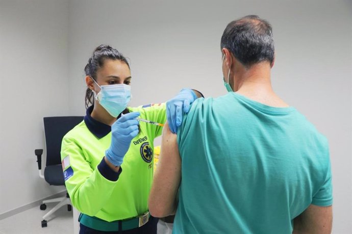 Archivo - Una profesional sanitaria administrando una vacuna contra el COVID-19 a un castellanomanchego