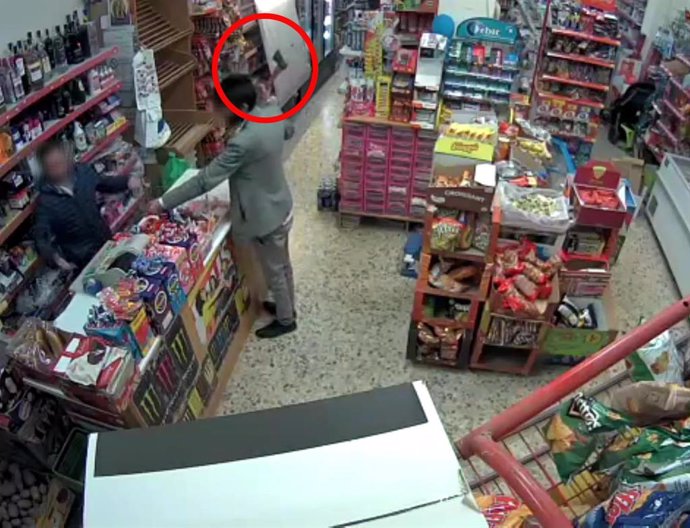 Un atracador amenaza a un cajero con un hacha