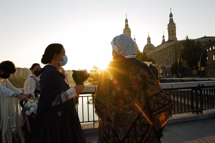 Mujeres vestidas de baturras se dirigen a la Basílica del Pilar para honrar y realizar la tradicional ofrenda de flores a la Virgen del Pilar el día de su festividad, a 12 de octubre de 2021, en Zaragoza.