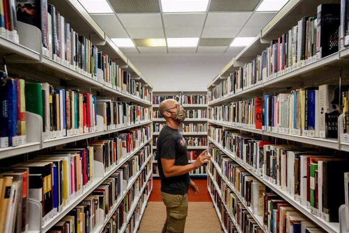Un hombre observa los libros de la biblioteca pública Elena Fortún, el primer día de fin de las restricciones de aforo en Madrid, a 4 de octubre de 2021, en Madrid (España). 