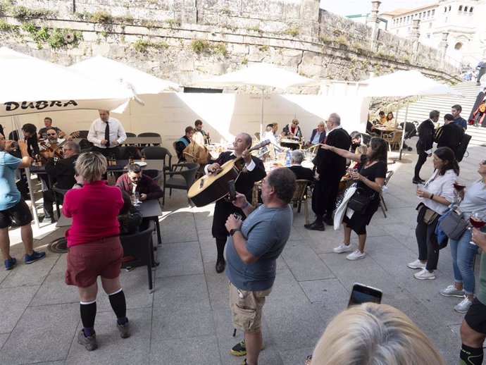 Un grupo de turistas canta con una tuna en una plaza de Santiago de Compostela, a 9 de octubre de 2021.