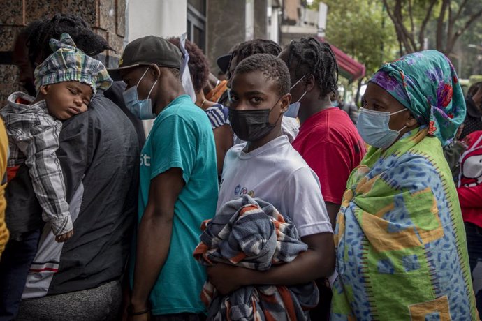 23 September 2021, Mexico, Mexico City: Migrants queue in front of the The Mexican Commission for Refugee Assistance office, where they want to apply for asylum. Migrants from Haiti have arrived in the Mexican capital from the south in the last three da
