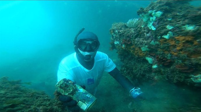 PErsona recogiendo residuos en el mar