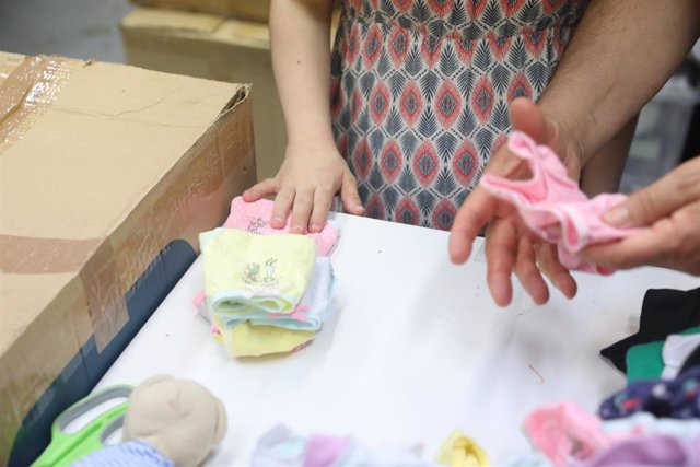 Archivo - Varias voluntarias preparan ropa en la Fundación Red Madre, que proporciona ayuda a mujeres embarazadas y madres recientes.