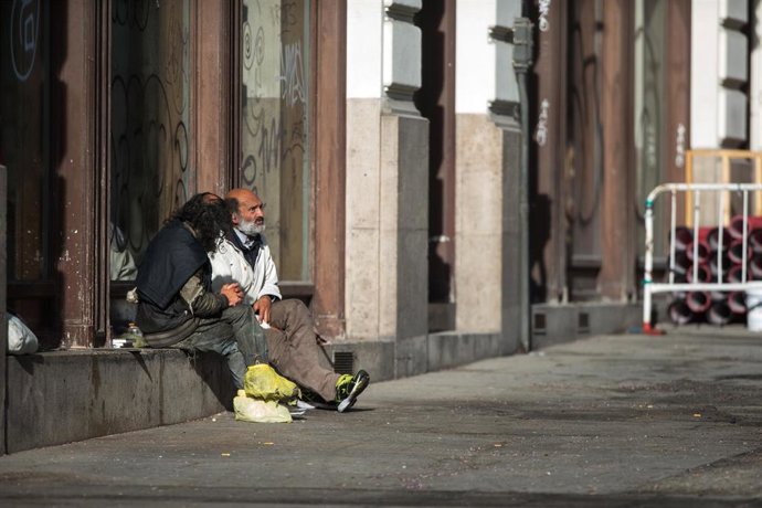 Archivo - Dos indigentes sentados en un escaparate