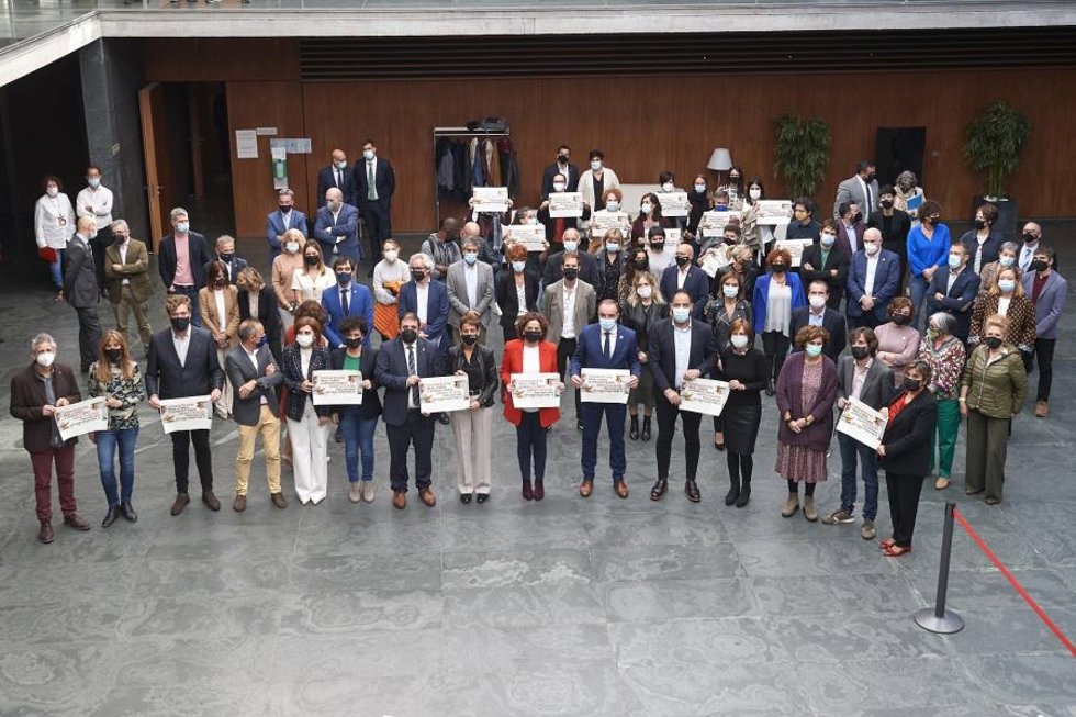 Los grupos parlamentarios posan en un acto contra la pobreza en el Parlamento de Navarra.