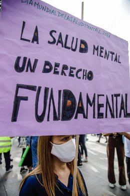 Una mujer sostiene una pancarta donde se lee "La salud mental un derecho fundamental", en una marcha con motivo del Día Mundial de la Salud Mental, foto de archivo