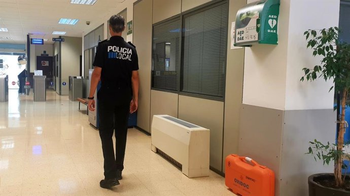 Un agente de la Policía Local pasa junto a un desfibrilador en dependencias policiales.