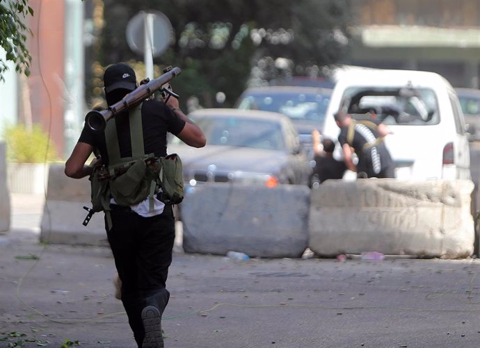 Un militante musulmán chiíta intenta disparar un lanzagranadas propulsado por cohetes durante los enfrentamientos en la zona de Tayouneh, después de que se produjeran disparos en una protesta contra el juez que investiga la explosión.