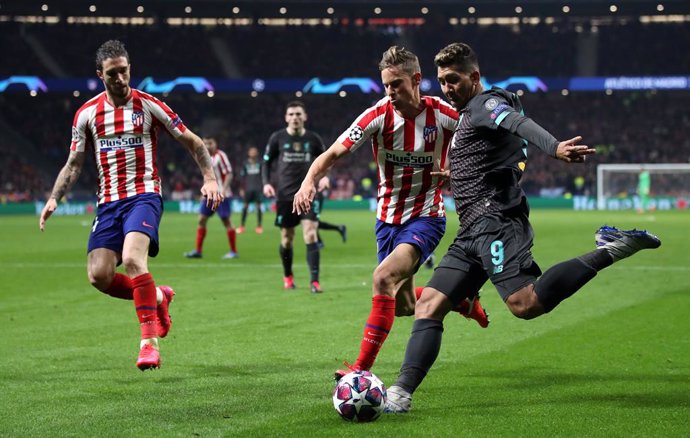 Archivo - 18 February 2020, Spain, Madrid: Atletico Madrid's Marcos Llorente (C) and Liverpool's Roberto Firmino (R) battle for the ball during the UEFA Champions League round of 16 first leg soccer match between Atletico Madrid and Liverpool at Wanda M