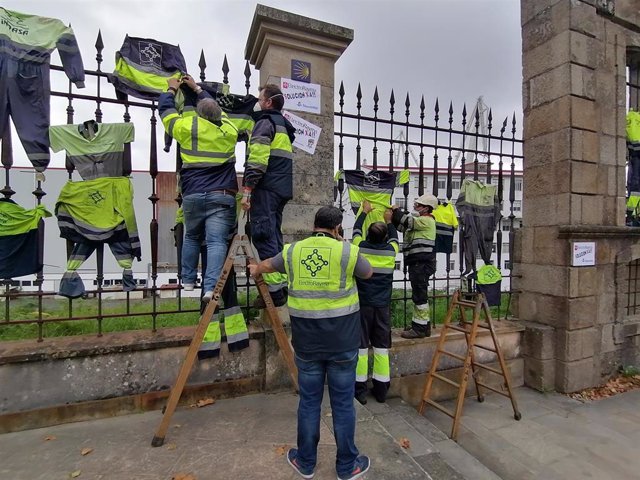 Ogperarios de ElectroRayma colgando su ropa de trabajo de la verja de Navantia Ferrol.