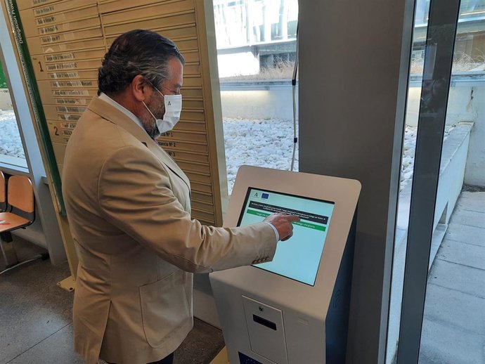 El delegado de Regeneración, Justicia y Administración Local de la Junta en Huelva, Alfredo Martín, prueba una de las nuevas máquinas para cita previa en el Registro Civil.