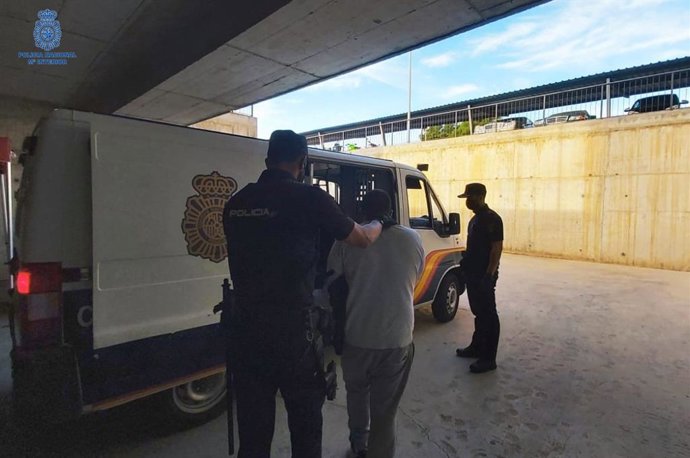 Agentes de la Policía Nacional junto a uno de los detenidos.
