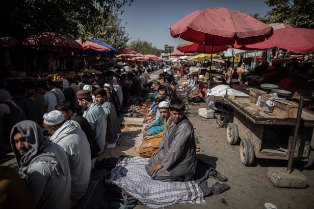 17 September 2021, Afghanistan, Kunduz: Afghani men attend Friday prayers on a street outside a mosque in Kunduz, northern Afghanistan. Photo: Oliver Weiken/dpa