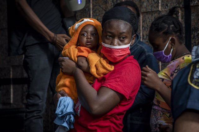 Una mujer de Haití espera con su hijo para pedir asilo en la capital de México, Ciudad de México