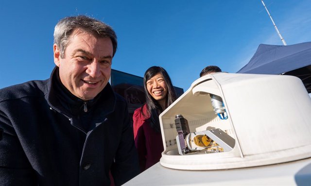 11 October 2021, Bavaria, Munich: Markus Soeder (L), Minister-President of Bavaria, and Jia Chen, Professor of Environmental Sensors and Modeling at the Technical University of Munich (TUM), stand on top of a building in the city centre behind a measuring